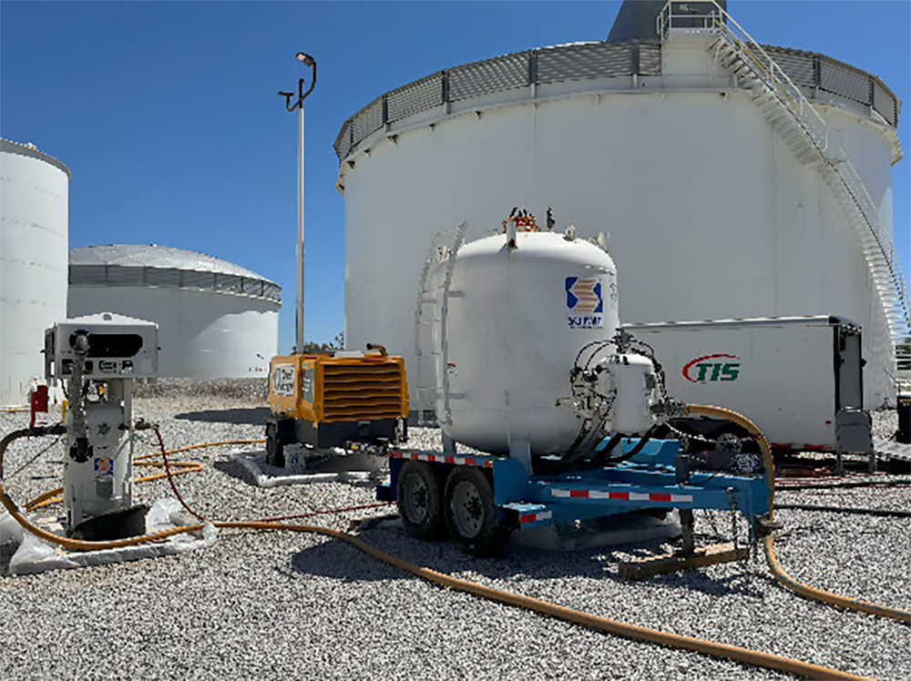 TIS equipment in front of a white chemical storage tank