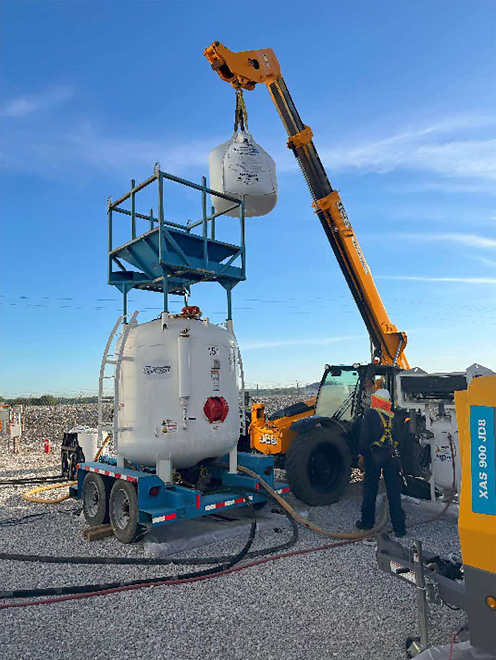 TIS equipment in front of a white chemical storage tank